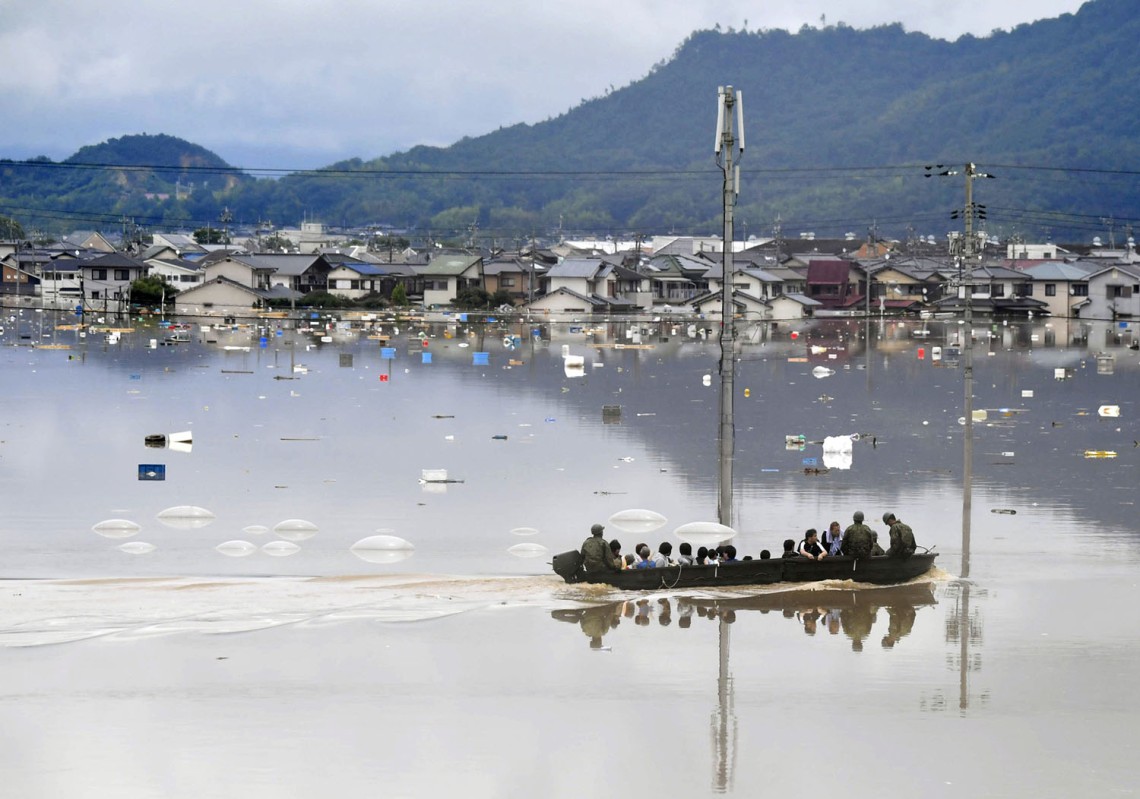 Residents are rescued from a flooded area by Japan Self-Defense Force soldiers in Kurashiki