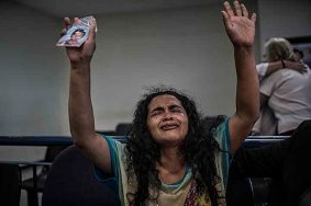 San Salvador, El Salvador-May 2016: Maria Teresa Rivera reacts to her sentence annulement in Federal Court, chanting "Dios Existe" with a photo of her son, Oscar in her hand. The Supreme Court annulled María Teresa Rivera's 40 year sentence for aggravated homicide of her prematurely born infant after she had already served 4 years in jail, barely able to see her son who was being taken care of by her ill mother in a violent gang controlled neighborhood. After a careful review of the medical evidence and all the facts the judge stipulated that there was not enough proof of evidence that she intentially killed her child and ordered that reparations be made to her for her time served. Pregnant women in today's El Salvador face a whole host of challenges from the threat of the mosquito born illness, Zika which has been linked to the grave condition of microcephaly in newborns, to the constant threat of gang violence with one of the highest murder rates in the world, to an increasing rape epidemic. However the most important threat to women's reproductive rights is by far the State's criminal ban on abortion. Doctors and nurses are trained to spy on women's uteruses in public hospitals, reporting any suspicious alteration to the authorities and provoking criminal charges which can lead to between 6 months to 7 years in prison. It is the poorer class of women who suffer the most as doctors in private hospitals are not required to report. Roughly 25 women are serving 30 to 40 year sentences on homicide charges for allegedly killing their newborn children. Although the women's stories, most of which resemble premature births or late term miscarigaes are often dismissed in trials, laced with moral accusations, based little on the consitution and scientific facts. ©Nadia Shira Cohen